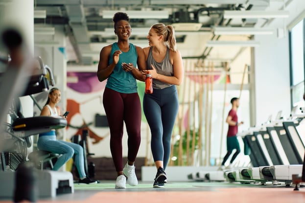 Two women at gym laughing