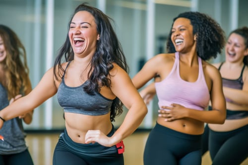 ClubOS | Two women laughing during group workout class